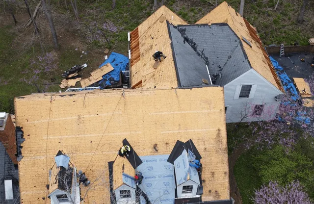 Aerial view of a home mid re-roof, with the old shingles torn off