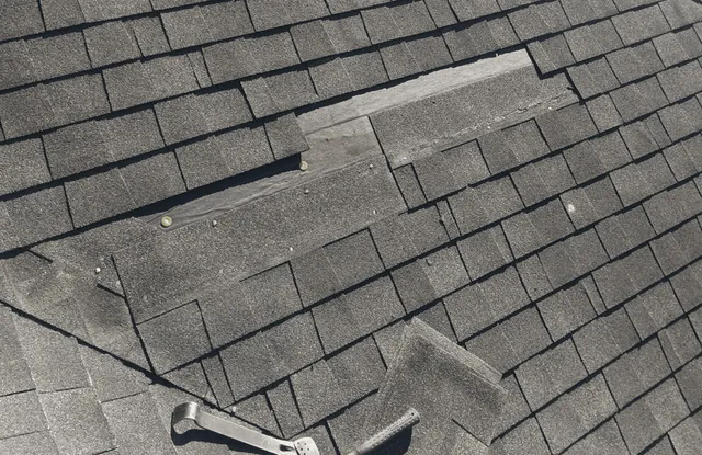 Close-up of storm-damaged shingles with a missing tab