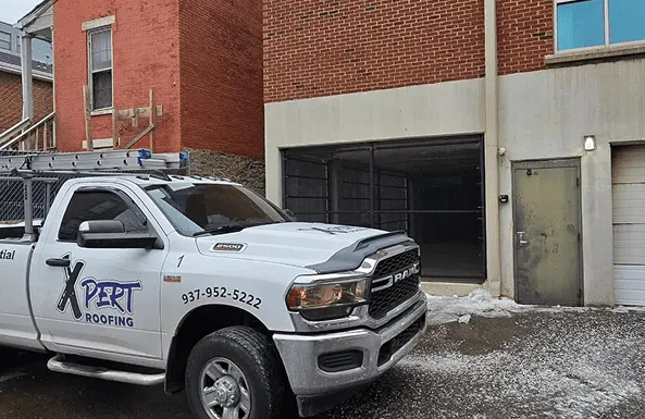 An Xpert Roofing pickup truck at a job site
